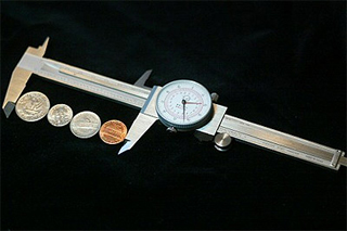 Calipers around several coins.