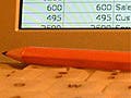 A close-up of a pencil sitting on top of a latop.