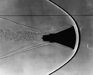 Mercury space capsule model with visible shockwaves and wake.