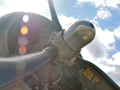 An aircraft engine with blue sky and white clouds in the background