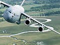 Photo of C-17 transport aircraft banking over a field.