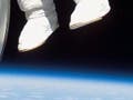 Photograph of astronaut outside space station.