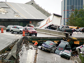 Scene of cars resting on a collapsed bridge.