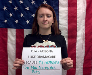 A young woman holds a sign reading "I like Obamacare Because My Grandma Can Now Afford Her Meds."