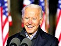 A smiling Joe Biden speaks from behind a podium with a sign reading “Battle for the Soul of the Nation”.