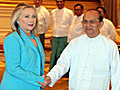 Hillary Clinton, in a teal pants suit, shakes the hand of Thein Sein, who is wearing a white buttoned shirt and teal lungi, a traditional Burmese garment, like a sarong.