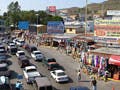 Cars wait in line on a road lined with shops at the US/Mexican border.