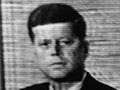 The grainy image on a television screen shows John F. Kennedy and Richard Nixon standing at podiums.