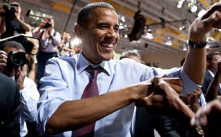 In a crowd, President Obama shakes hands.