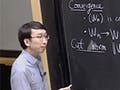 A man standing next to a blackboard.