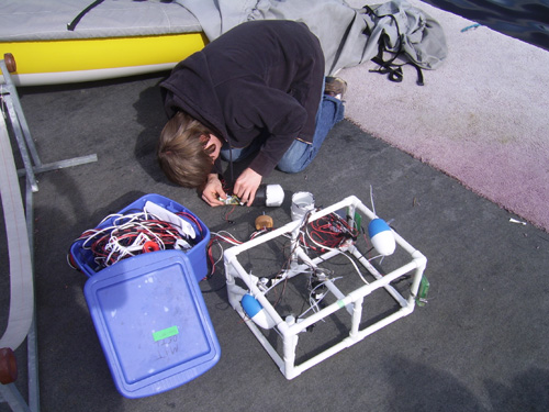 A student repairs electronics stored inside a PVC buoy.