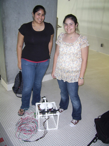 Two students with their robot and coiled-up tether.