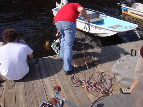 The multi-stranded tether coils up on the dock as a student hauls in the robot.