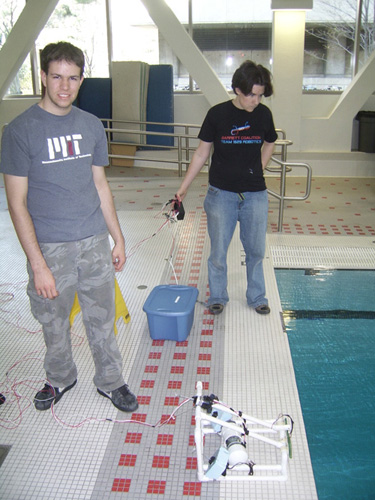 Two students whose robot has a sloping top.