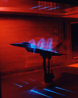 Photo of F-16 jet model in a wind tunnel test.