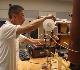 Prof. Wai Cheng works with lab equipment.