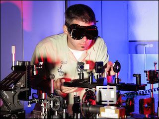 Researcher working with an optics table in laboratory.