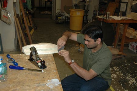 Fine shaping with a cabinet scraper.  Other key tools: chisel (foreground), spokeshave (left), and medium plane (right).
