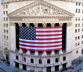A tall, stately building with an American flag draped across six pillars.