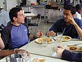 Students having a conversation in a cafeteria.