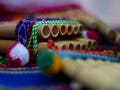 Photograph of a pan flute on a colorful blanket.