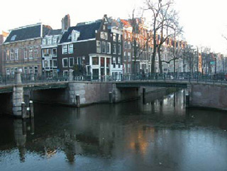 Traditional Dutch buildings with a canal in the foreground.