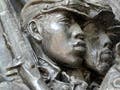 Photo of a metal relief sculpture of Civil War-era soldiers marching with rifles and gear.