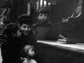 Black and white photo of two girls and two boys, standing in front of a shoeshine stand.
