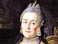 A serene-looking, grey-haired woman, adorned in a colorful, low-bodiced robe, sits on a throne, with a scepter in her hand.