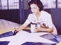 Woman painting American insignia on airplane wings, 1942.