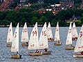 Photograph of boats on Charles River with city of Boston in the background.