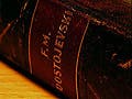 Close-up of the the spine of a book bound in deep brown leather.