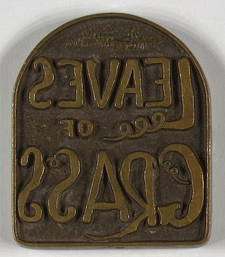 Brass plate with raised words "Leaves of Grass" as a mirror image.