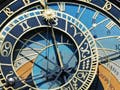 Photo of an ornate clockface with sun and moon hands, adjacent to statues of a skeleton and musician.
