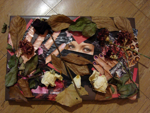 A woman's eyes peek out between two hands wearing pink and purple nail polish. Red paper squares, patches of purple and orange sparkles, and dried leaves and flowers surround and overlay the face.