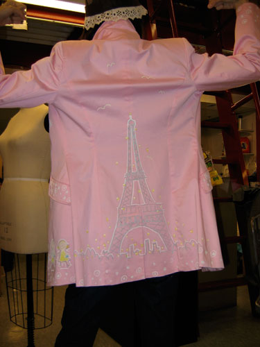 From the back, an outsize Eiffel Tower dominates the skyline, with birds flying overhead.