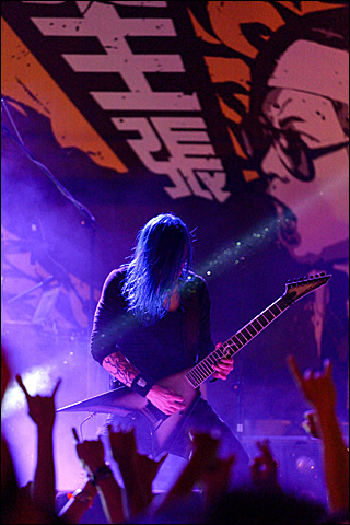 A man on stage playing the electric guitar in a concert.