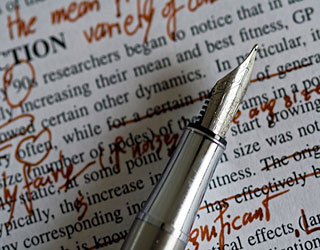 Fountain pen laying on top of typed text with handwritten edits.