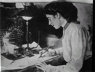 Black and white photo of woman writing at a desk
