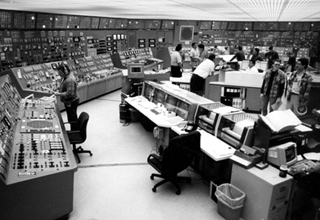 Photo of large control room, showing many screens and devices.