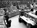 Photo of large control room, showing many screens and devices.