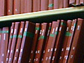 Photo of hardbound academic theses on library shelves.