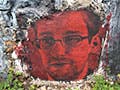 A red-tinted painting of a bespectacled young man with a goatee.
