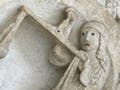 A photograph of a stone sculpture of Libra and her scales on Autun Cathedral.
