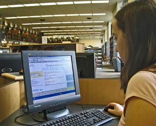 A student at a computer terminal in the library.