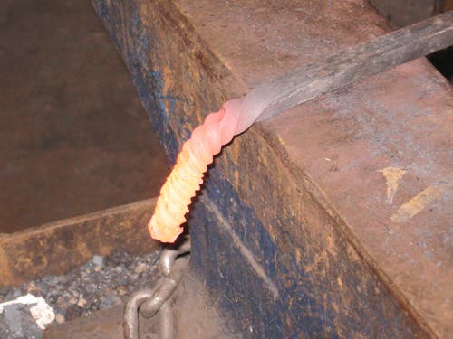 The yellow-hot bent end, close up. The twists are tighter near the end.