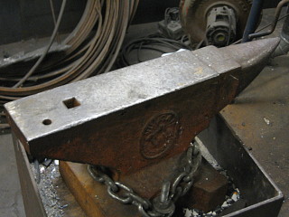 Photo of an anvil chained to a block stand.