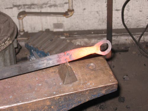 The hardy has a triangle profile, and comes to a relatively sharp point at the top. Here it is cutting off a red-hot bottle opener.