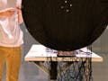 Student spinning yarn on a weaving wheel.