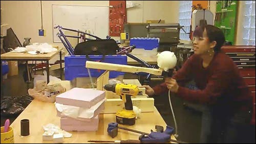 Student with wooden catapult and power tools.
